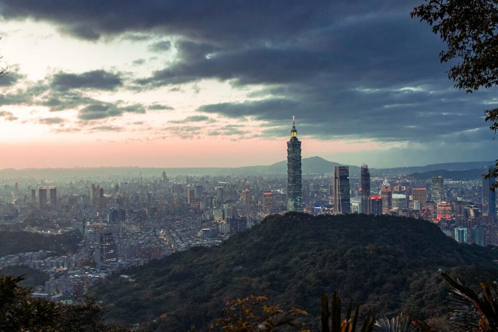 Stunning view of Taipei city skyline featuring Taipei 101 at dawn with morning fog and dramatic sky.