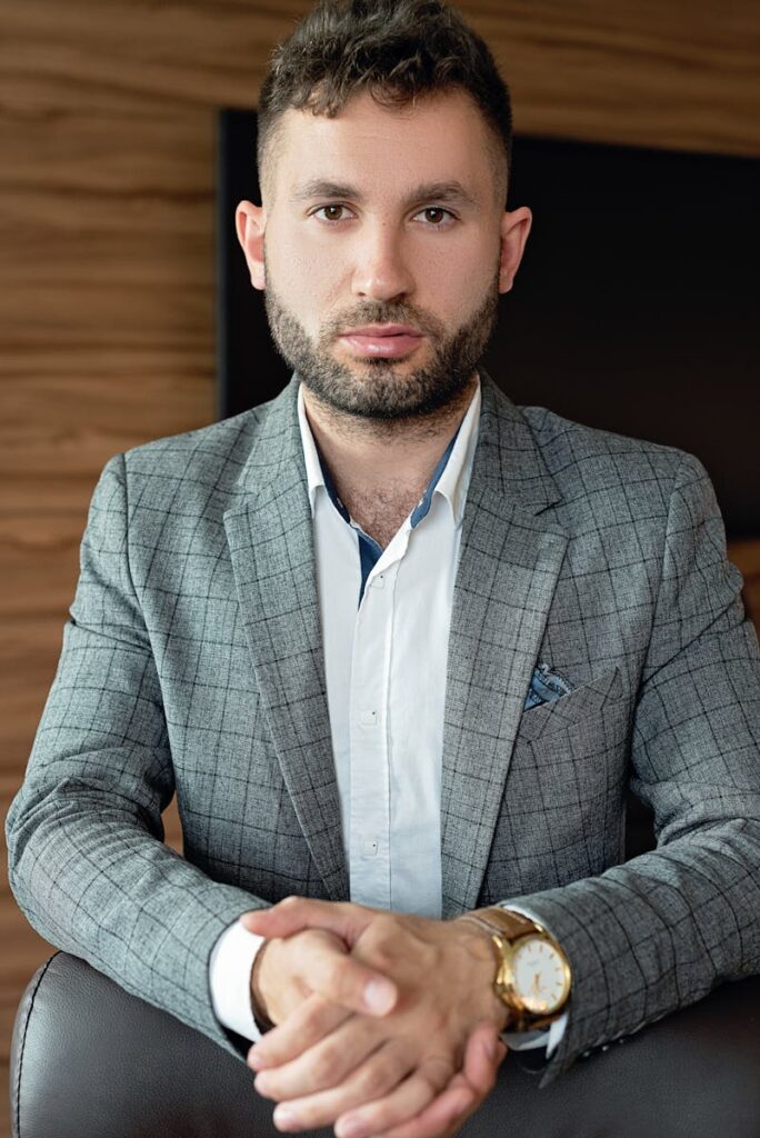 Professional businessman posing confidently in a stylish gray suit indoors.